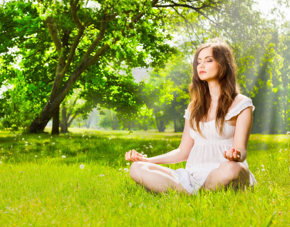 Young woman doing yoga in spring park